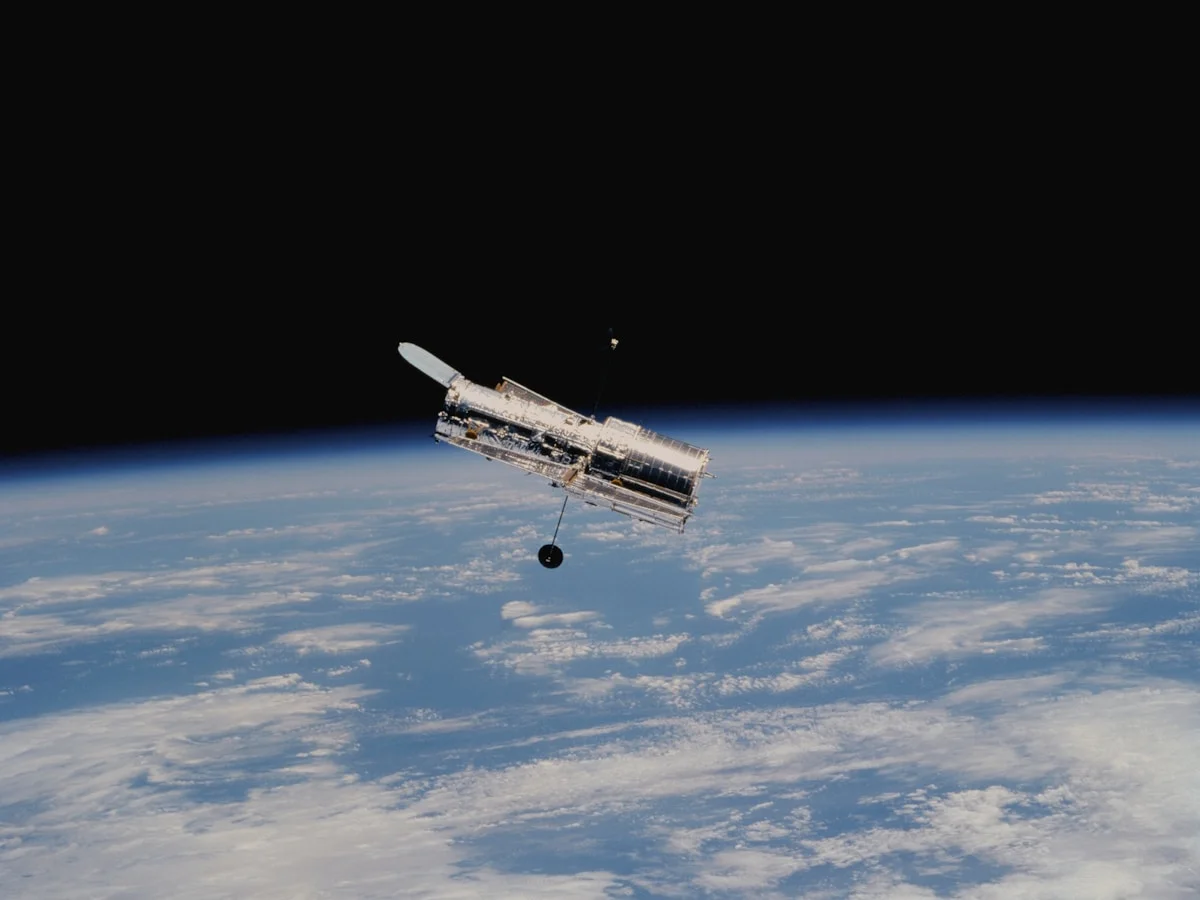 Spacecraft solar panel array deployed against the dark background of space showing gold-tinted multi-junction cells facing the sun