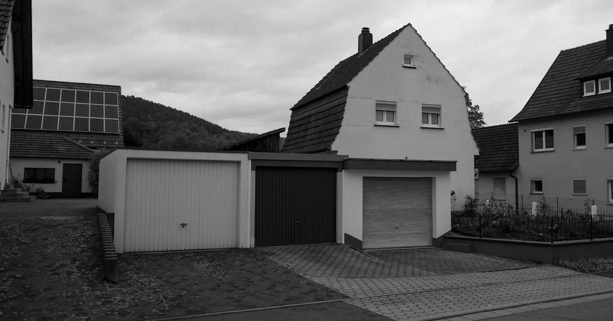 Two garages attached to a house with solar panels on the roof