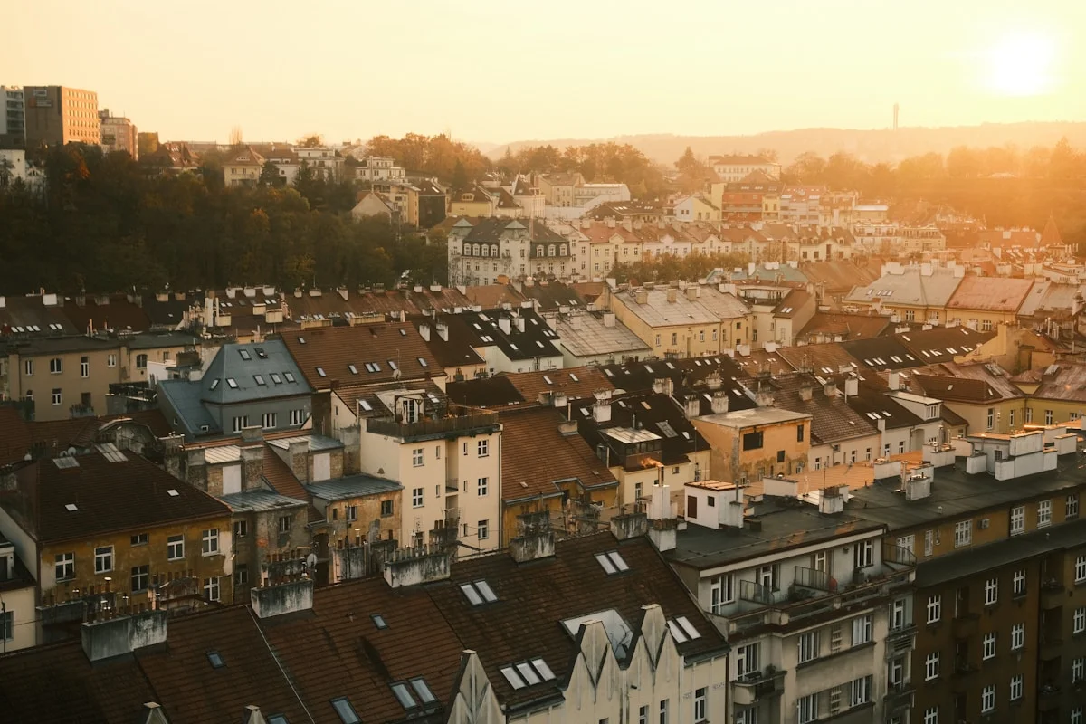 Rooftops of a European city glowing at sunset