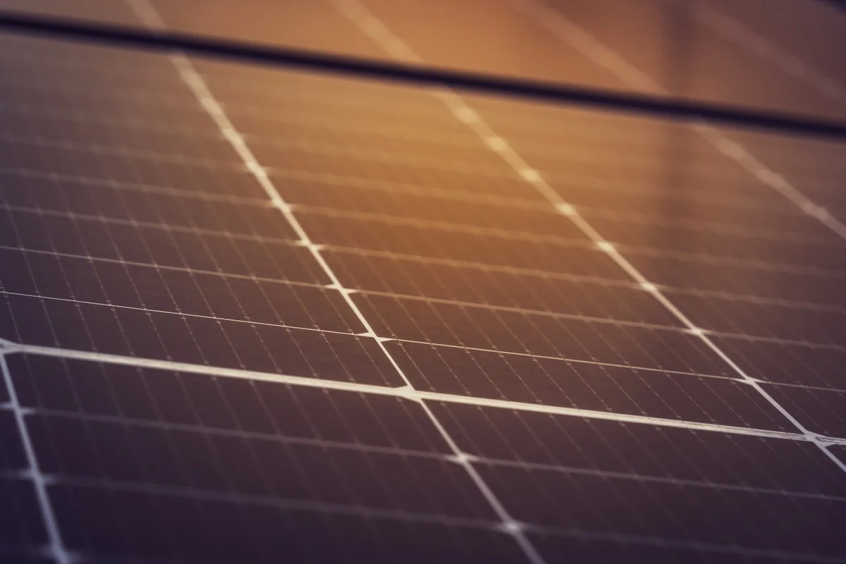 Close-up of dark blue-black monocrystalline solar panel cells showing the anti-reflective coating and busbar pattern