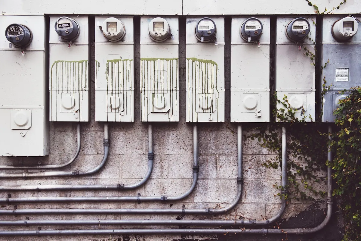 Row of gray electricity meters mounted on a wall