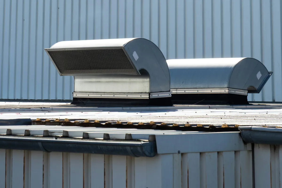 Two large ventilation units mounted on the flat roof of a building