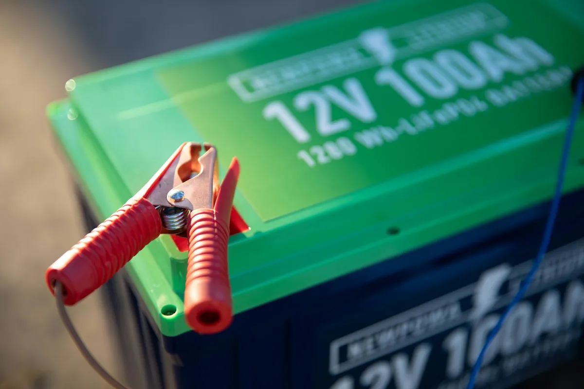 A lithium battery terminal being tightened with insulated pliers