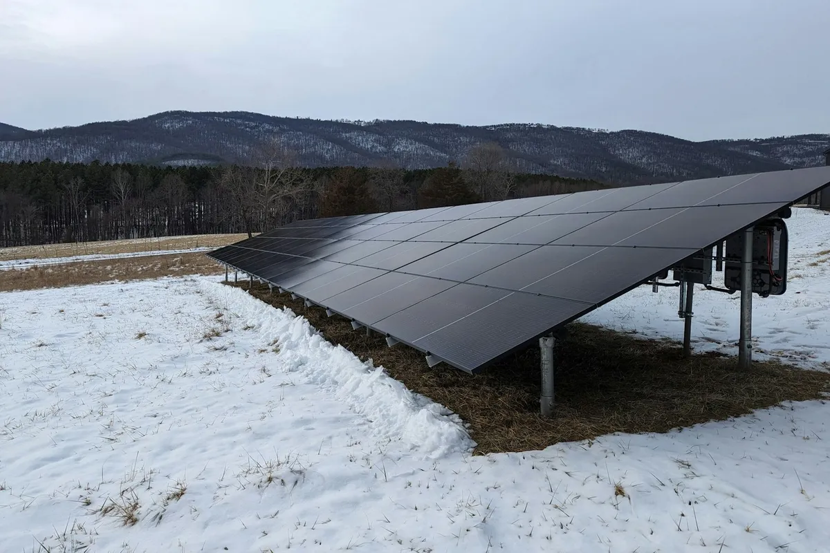 A ground-mounted solar array installed in a snow-covered field