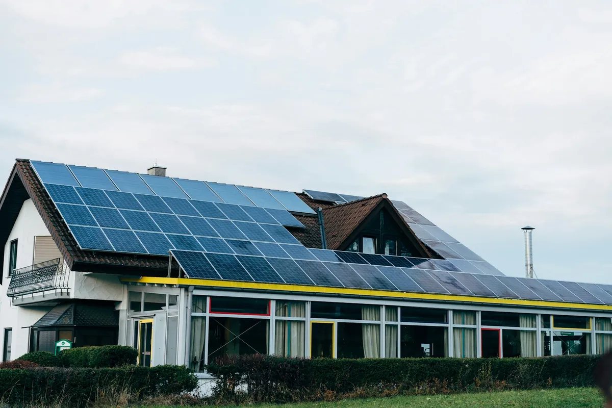 White house with a large array of solar panels covering its sloped roof