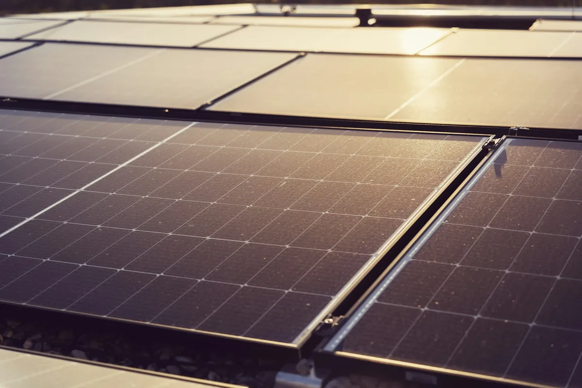 Close-up of dark monocrystalline solar panels mounted in rows on a roof