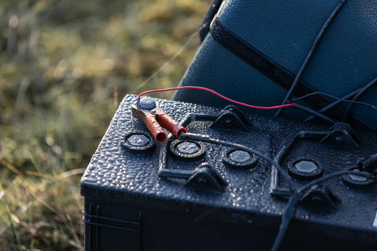 Compact storage battery wired to a panel at ground level outdoors