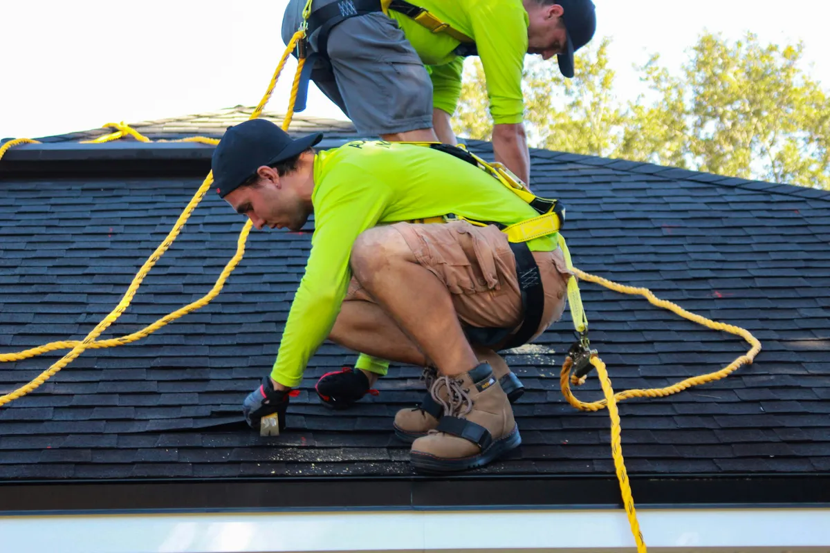 Two installers working across an existing roof during a retrofit job